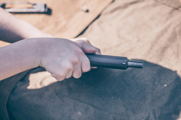 The boy performs disassembly, cleaning and assembly of the pistol