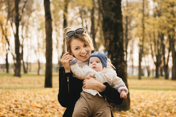 Portrait of a young mother with her baby in the autumn Park.