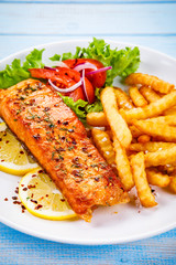 Fried salmon, French fries and vegetables 