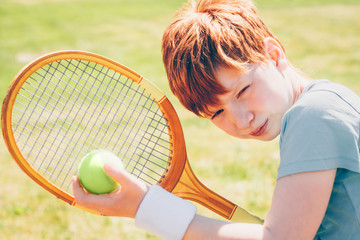 Young red-haired tennis player is determined to win