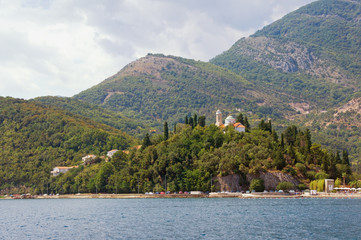 Fototapeta na wymiar Cloudy Mediterranean landscape. Montenegro, Bay of Kotor, Adriatic Sea. View of Kamenari village with Church of Sveta Nedjelja