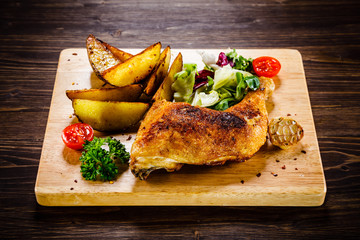 Grilled chicken leg with baked potatoes and vegetables 