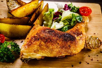 Grilled chicken leg with baked potatoes and vegetables 