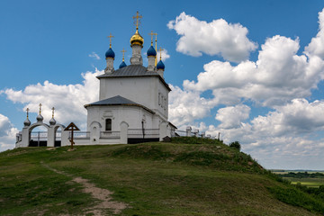 Fototapeta na wymiar Church standing on a high and green hill