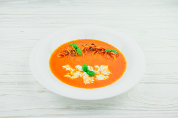 pumpkin cream soup, on a white wooden background