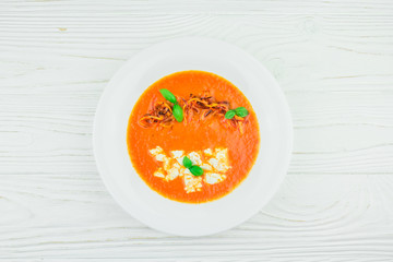 pumpkin cream soup, on a white wooden background, top view