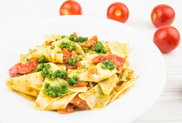 Italian pasta with tomatoes and pesto sauce, close-up