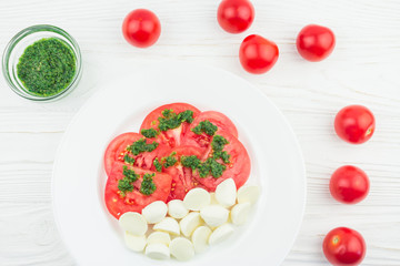 caprese with tomatoes and mozzarella and pesto sauce, top view