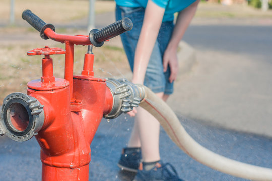 The Boy Spoils Water Splashes From The City Fire Hydrant On A Hot Summer Day