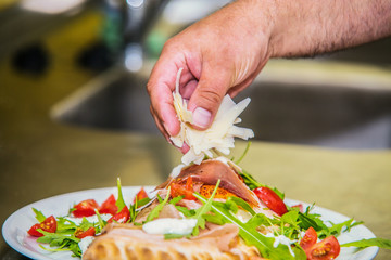 Close up hands of chef preparing pizza in the kitchen of a restaurant, cooking concept