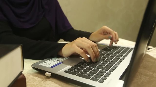 young muslim woman working at office desk, documents and computer
