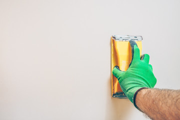 Finishing works - first person view - the master grinds the wall, copyspace