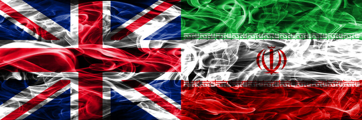 United Kingdom vs Iran smoke flags placed side by side. Thick colored silky smoke flags of Great Britain and Iran