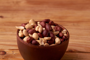 dry peanuts background. close up dry peanuts in clay bowl. Space for pext. Copyspace