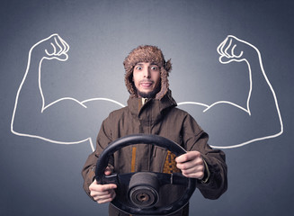 Young man holding black steering wheel with muscly arms drawn next to him