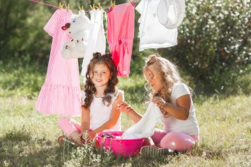 Two little girls laundring. Sisters doing housework