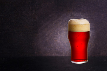 Glass of beer on wooden background with copyspace for text
