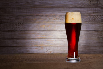 Glass of beer on wooden background with copyspace for text