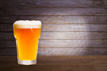 Glass of beer on wooden background with copyspace for text