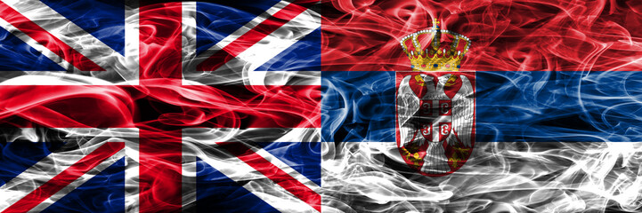 United Kingdom vs Serbia smoke flags placed side by side. Thick colored silky smoke flags of Great Britain and Serbia