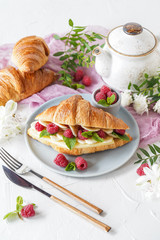 Breakfast with croissants, tea, bananas, confiture, cheese and berries on white background