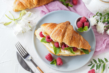 Breakfast with croissants, tea, bananas, confiture, cheese and berries on white background