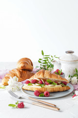 Breakfast with croissants, tea, bananas, confiture, cheese and berries on white background
