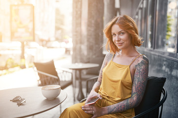 beautiful tattooed ginger girl in cafe