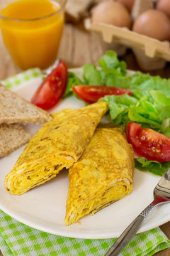 Rolled omelette with cheese served with vegetable salad
