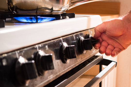 Man turning on burner to cook meal
