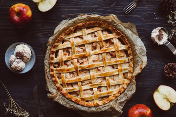 Homemade delicious apple pie with ice cream on the wooden table.