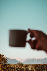 Kaffee in der Hand und Gruß in die Berge