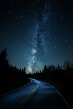 Curvy road with shooting star and Milkyway above