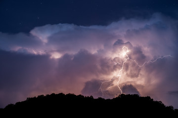 Lightning strike, passing storm and night sky