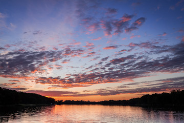 Fototapeta na wymiar Beautiful sunset at the summer lake with dynamic clouds