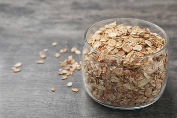 Glass with oatmeal on grey background. Grains and cereals