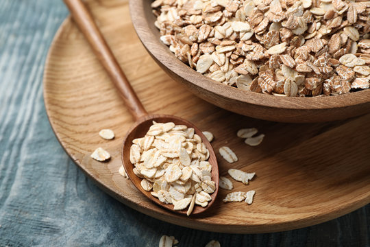 Dishware with oatmeal on wooden table. Grains and cereals