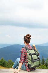 Woman with backpack in wilderness on cloudy day
