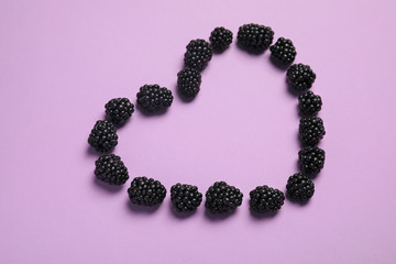 Composition with ripe blackberries on color background