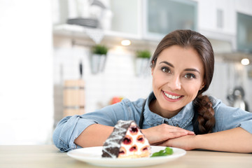 Professional female chef presenting dessert on table in kitchen