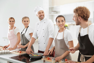 Group of people and male chef at cooking classes