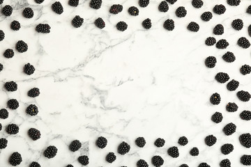 Flat lay composition with fresh blackberry and space for text on marble background