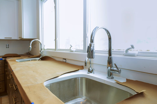 Stainless kitchen sink and Tap water in the kitchen. The interior of the kitchen room of the apartment. Built-In Appliances