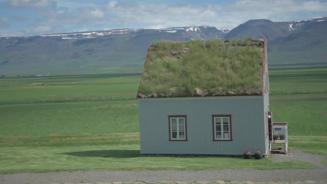 Old Farmhouse Laufas Glaumbaer farm Folk Museum turf roof houses in Varmahlid, Skagafjordur, Iceland, Europe. Icelandic tourist destination and attraction landmark. Woman walking in Icelandic sweater.