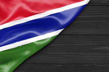 Flag of the Gambia and place for text on a dark wooden background