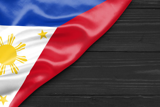 Flag of the Philippines and place for text on a dark wooden background