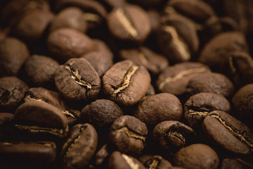 Coffee beans roasted on a wooden table with much of beans with a great aroma