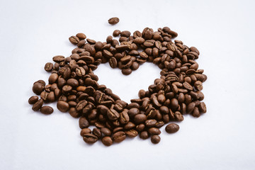 Heart with fresh roasted coffee beans on a white background with a great aroma