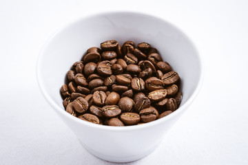 Cup of Coffee Beans roasted on a wooden table with fresh bean with great aroma