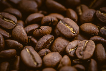 Coffee beans roasted on a wooden table with much of beans with a great aroma
